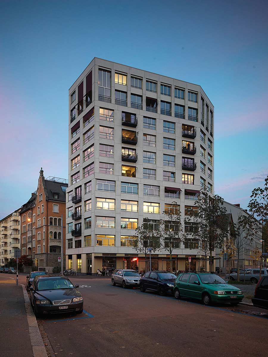 photo at dusk showing a tall apartment building in an urban setting