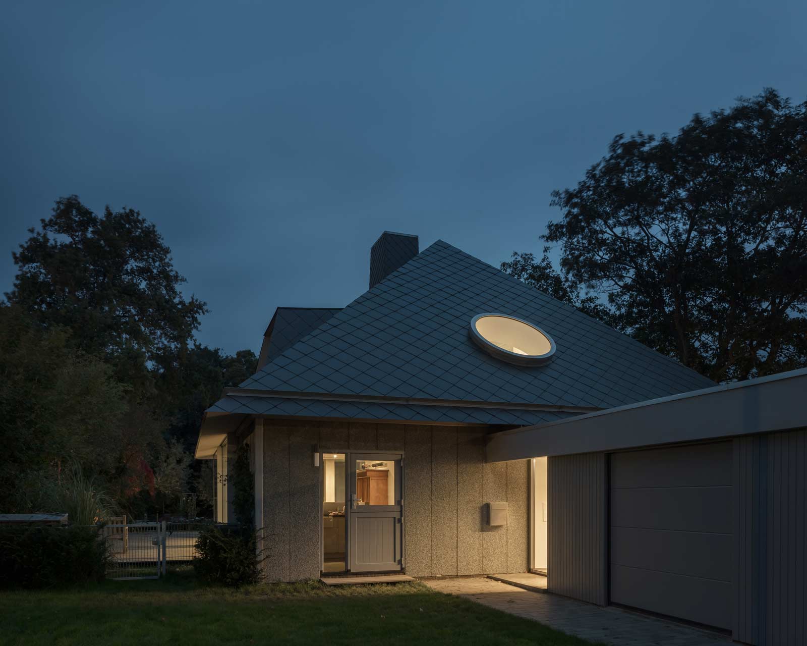 exterior night photo of house tc with circular roof light by beta architect amsterdam evert klinkenberg gus auguste van oppen image by Stijn Bollaert