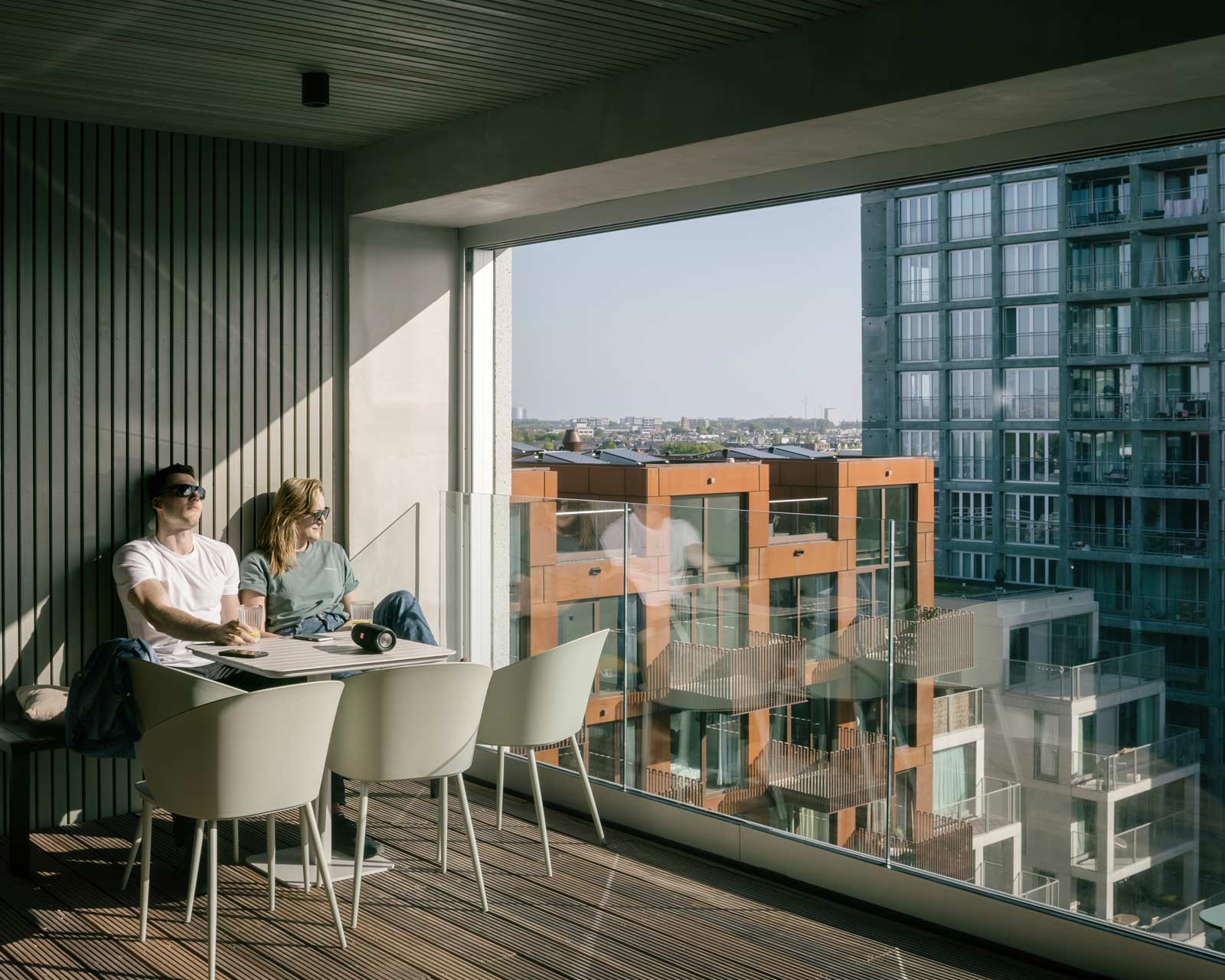 lobby 2 interior photo with couple sitting at a table of Oostenburg apartment block Draaier by BETA architect amsterdam evert klinkenberg gus auguste van oppen image by Stijn Bollaert